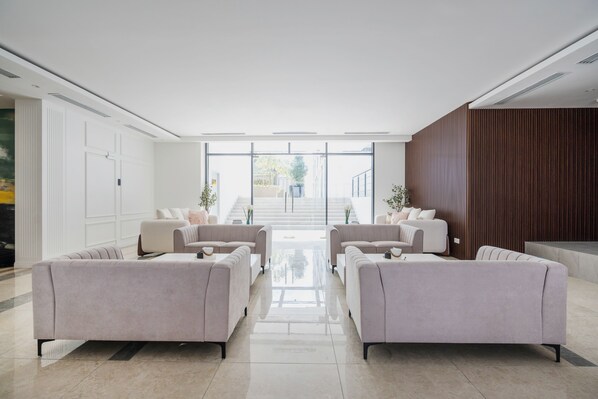 A modern lobby with a central seating area, large windows, and a staircase leading to upper floors. - FOX Hotel Glenmarie Shah Alam (Shah Alam)