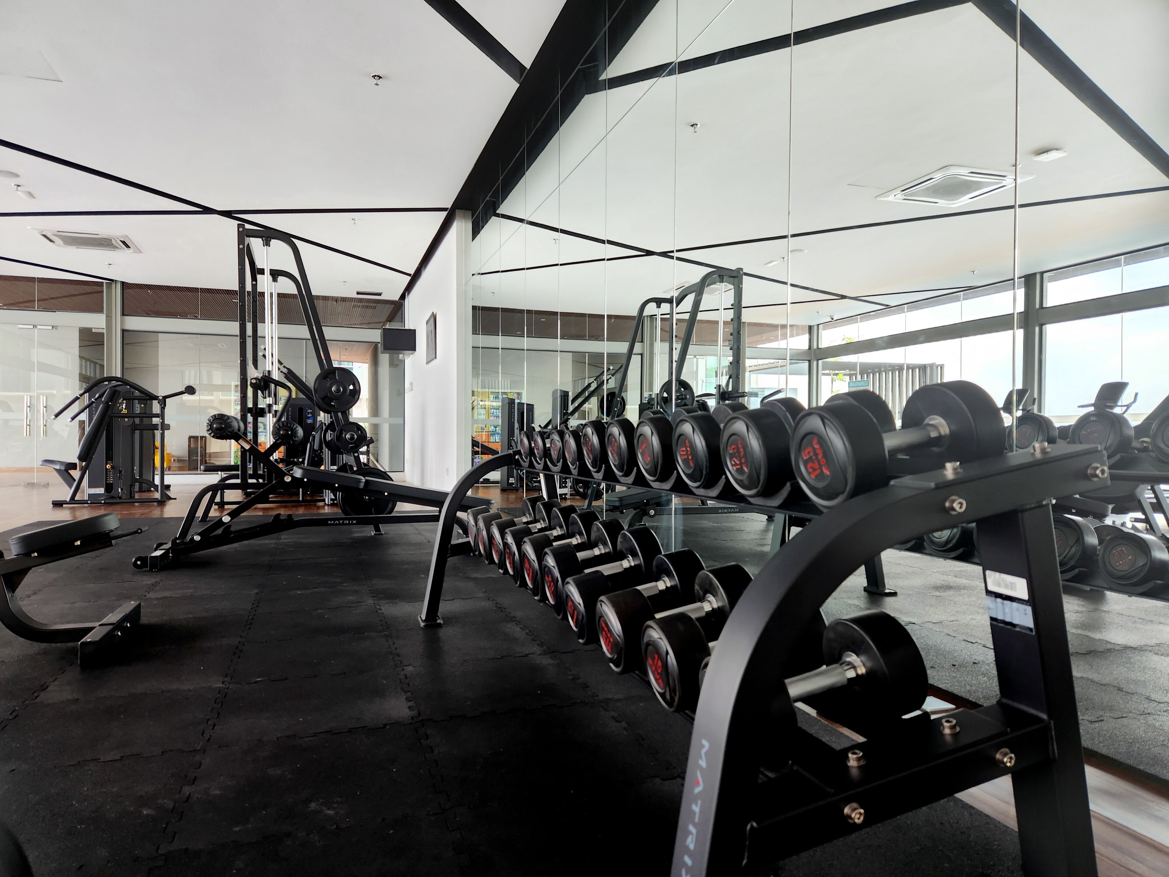 A gym with weightlifting equipment and cardio machines.
