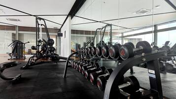 A gym with weightlifting equipment and cardio machines.