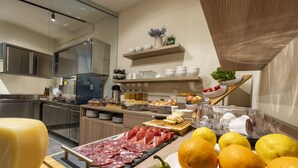 A kitchen with a charcuterie board, fresh fruits, and a variety of kitchen utensils. - Goloritzè Room and Breakfast (Baunei)