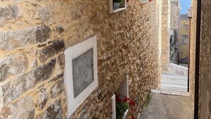 A stone-walled corridor with a narrow staircase leading to a higher level, potted plants, and a view of the sea. - Goloritzè Room and Breakfast (Baunei)