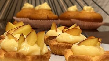A plate of mini tarts with a golden crust and topped with a creamy filling and sliced apples.