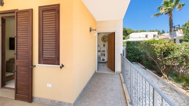 A building with a balcony, a door with shutters, and a view of the surrounding area. - 1650 Villetta Lucri by Barbarhouse (Nardò)