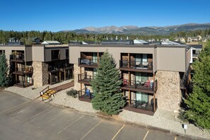 A multi-story hotel with balconies, stone facade, and a parking lot.