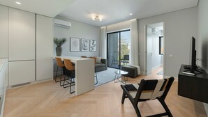A modern living space with a dining area, a sofa, a TV, and a balcony. - GuestReady - Urban Comfort near Clérigos Tower (Porto)