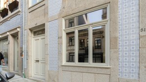 A building facade with numbered windows, a door, and a pedestrian walkway. - GuestReady - Urban Comfort near Clérigos Tower (Porto)