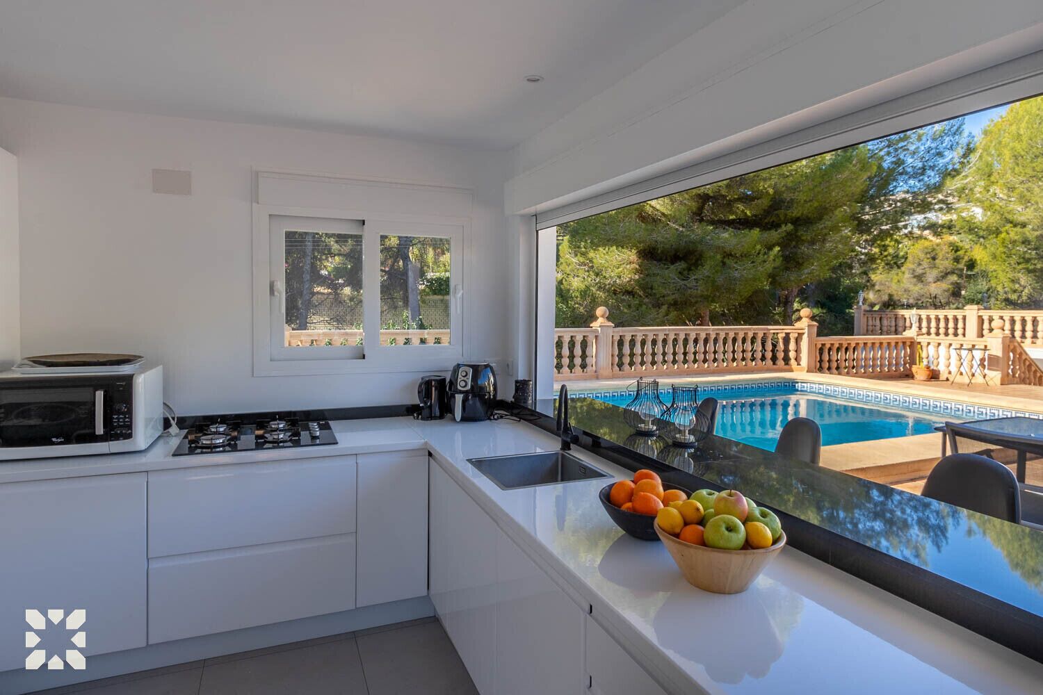 Une cuisine moderne donnant sur une piscine.