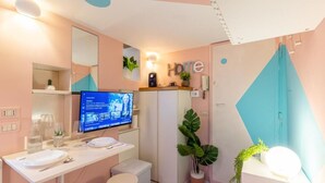 A modern bathroom with a vanity, mirror, sink, and a television displaying a movie. - Romantic Rome Retreat, Steps from Colosseum (Roma)