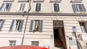 A building with multiple windows, a staircase leading to an entrance, and a no parking sign. - Romantic Rome Retreat, Steps from Colosseum (Roma)