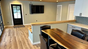 Una cocina moderna con suelo de madera, una isla central y armarios blancos.