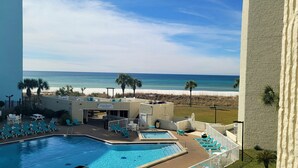 Poolbereich mit Liegestühlen und Blick auf den Strand.
