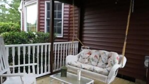 A porch with a white rocking chair, a white coffee table, and a floral sofa. - Secluded Private Guesthouse - Doylestown Twp

 (Doylestown)