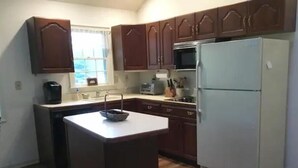 A kitchen with wooden cabinets, a refrigerator, a microwave, and a sink. - Secluded Private Guesthouse - Doylestown Twp

 (Doylestown)