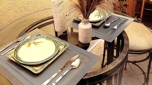 A dining table with a vase of pampas grass, plates, cutlery, and a chair. - Romantic 14th floor w/ a WOW view! Oceanfront King, full condo, pools & hot tubs (Myrtle Beach)