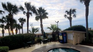 A pool area with palm trees, a Pepsi vending machine, and a lifeguard station. - Romantic 14th floor w/ a WOW view! Oceanfront King, full condo, pools & hot tubs (Myrtle Beach)