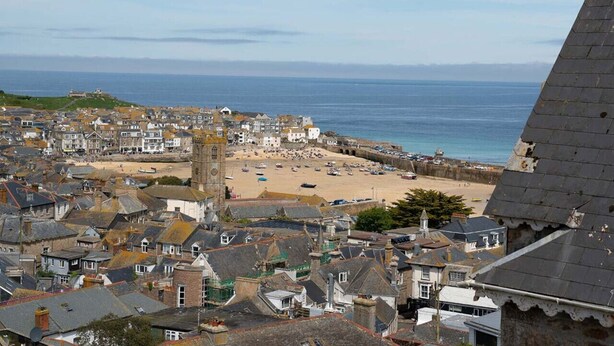 A coastal town with a beach, historic buildings, and a prominent tower. - Sea View Modern 1BR Apartment near to centre (St Ives)