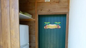 Una porta in legno con una maniglia verde e un cartello di benvenuto.