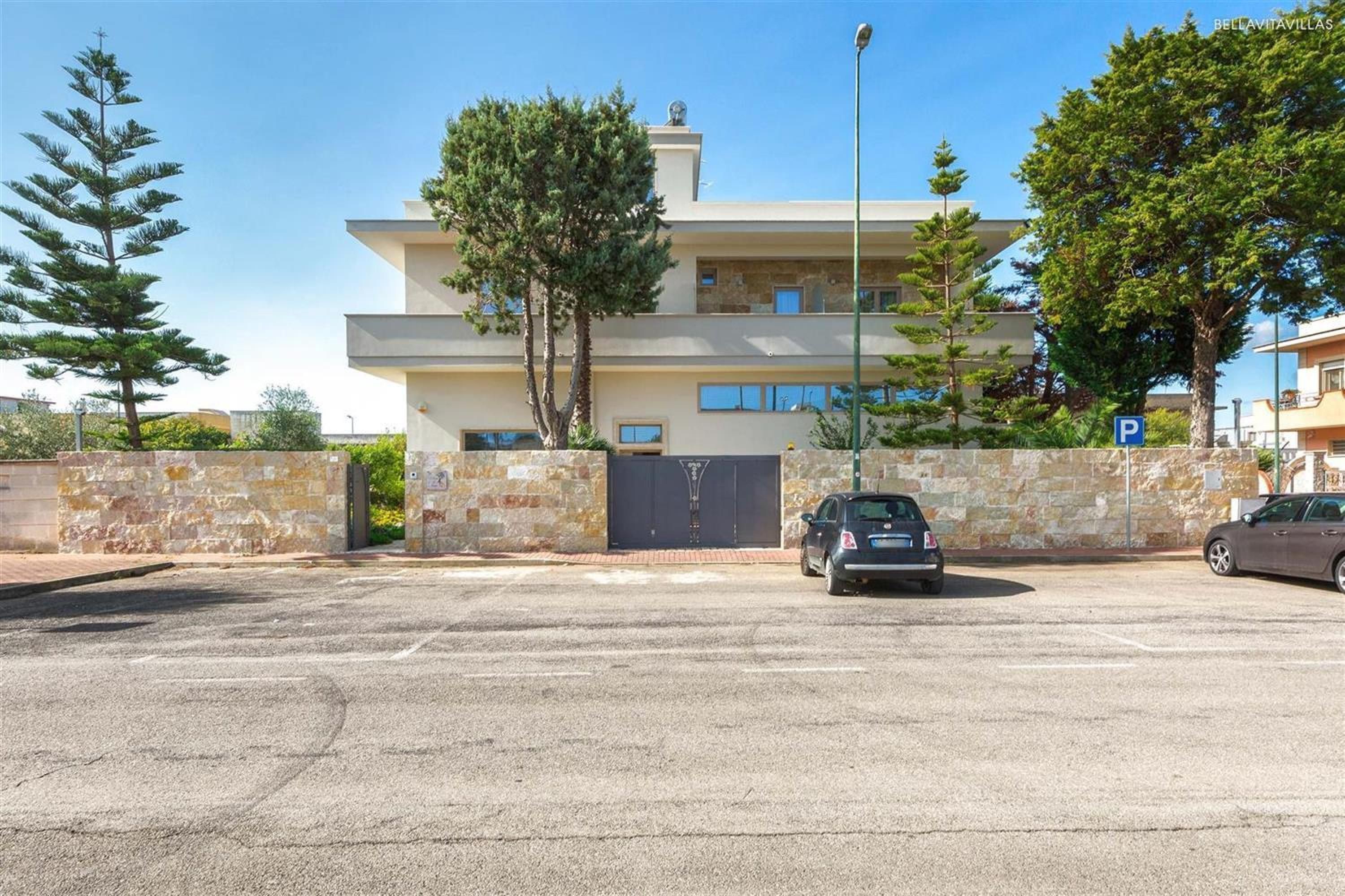 Un immeuble à plusieurs étages avec un espace de stationnement à l’avant.