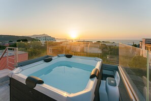 A hot tub on a rooftop with a view of the sunset over the sea. - Le rondinelle rooms  (Procida)