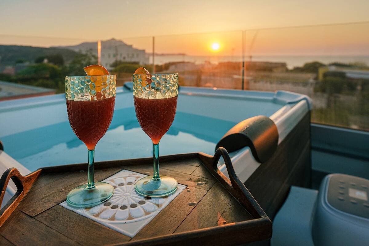 Two drinks on a tray with a pool view.