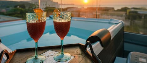 Duas bebidas sobre uma bandeja, com vista para a piscina.