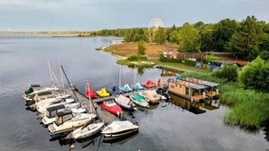 A marina with various boats docked, a Ferris wheel, and a building with a sloped roof. - Seeloft Senftenberg 1 (Senftenberg)