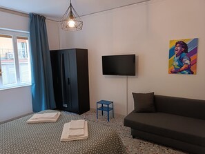 A bedroom with a bed, a TV, a painting, and a wardrobe. - B&B Napoli Fuorigrotta (Naples)