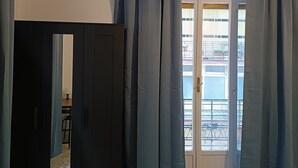 Et værelse med et mørkt skab, en dør der fører udendørs, og et terrazzo gulv.