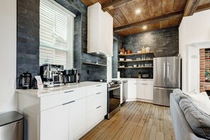 A modern kitchen with white cabinetry, a built-in oven, a microwave, and a refrigerator. - The Nook at Legacy Manor (Lancaster)