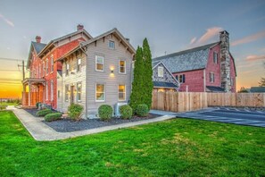 A two-story house with a front yard and a wooden fence. - The Cottage at Legacy Manor (Lancaster)