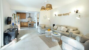 Een moderne woonkamer met een zithoek, een salontafel en een keuken op de achtergrond.