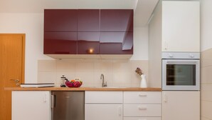 Una cocina moderna con lavavajillas, horno y encimera de madera.