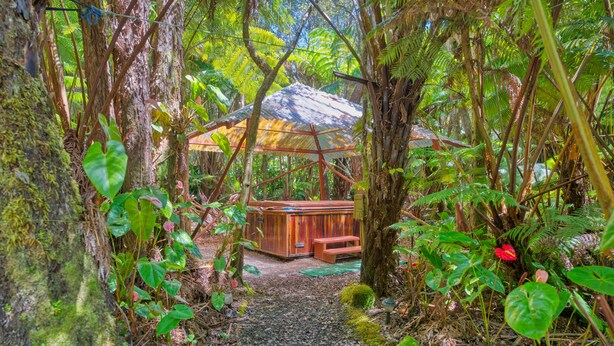 A wooden gazebo in a forested area with a bench and a hot tub. - The Pacifica Inn/ The Gecko and Volcano Room (Volcano)