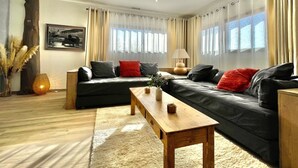 A modern living room with a sofa, a wooden coffee table, and a lamp. - Les Terres Rouges du Salagou 5min du lac ! Natura 2000 , Atelier D'artiste (Le Bosc)