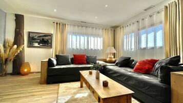 Een moderne woonkamer met een bank, een houten salontafel en een lamp.