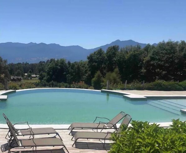 Relax by the serene pool surrounded by a mountain view.