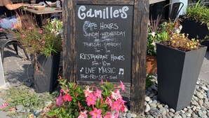 A cafe signboard with business hours and live music information. - Gorgeous new beach cottage in fantastic location! (Destin)