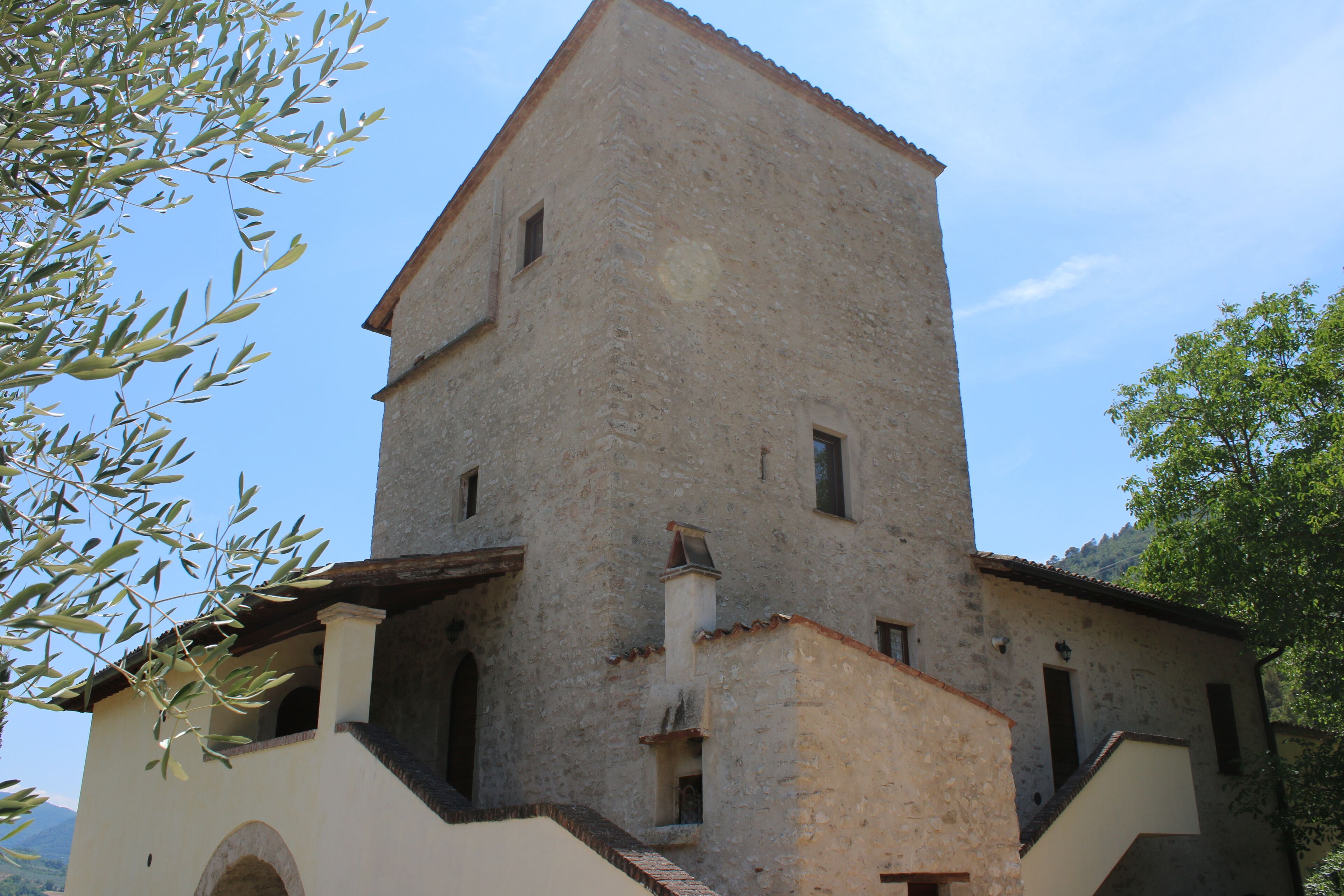 A historic building with a prominent tower, arched windows, and a balcony.