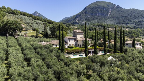 A villa surrounded by olive trees and cypress trees, with a mountain in the background. - Appartamenti Santa Croce (Ferentillo)