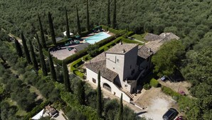 An aerial view of a property with a swimming pool, a large building with a tiled roof, and a surrounding forested area. - Appartamenti Santa Croce (Ferentillo)