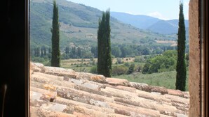 A view through a window of a stone staircase leading to a hillside. - Appartamenti Santa Croce (Ferentillo)