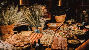 A buffet table with various food items and decorative plants. - Brach Madrid - Evok Collection (Madrid)