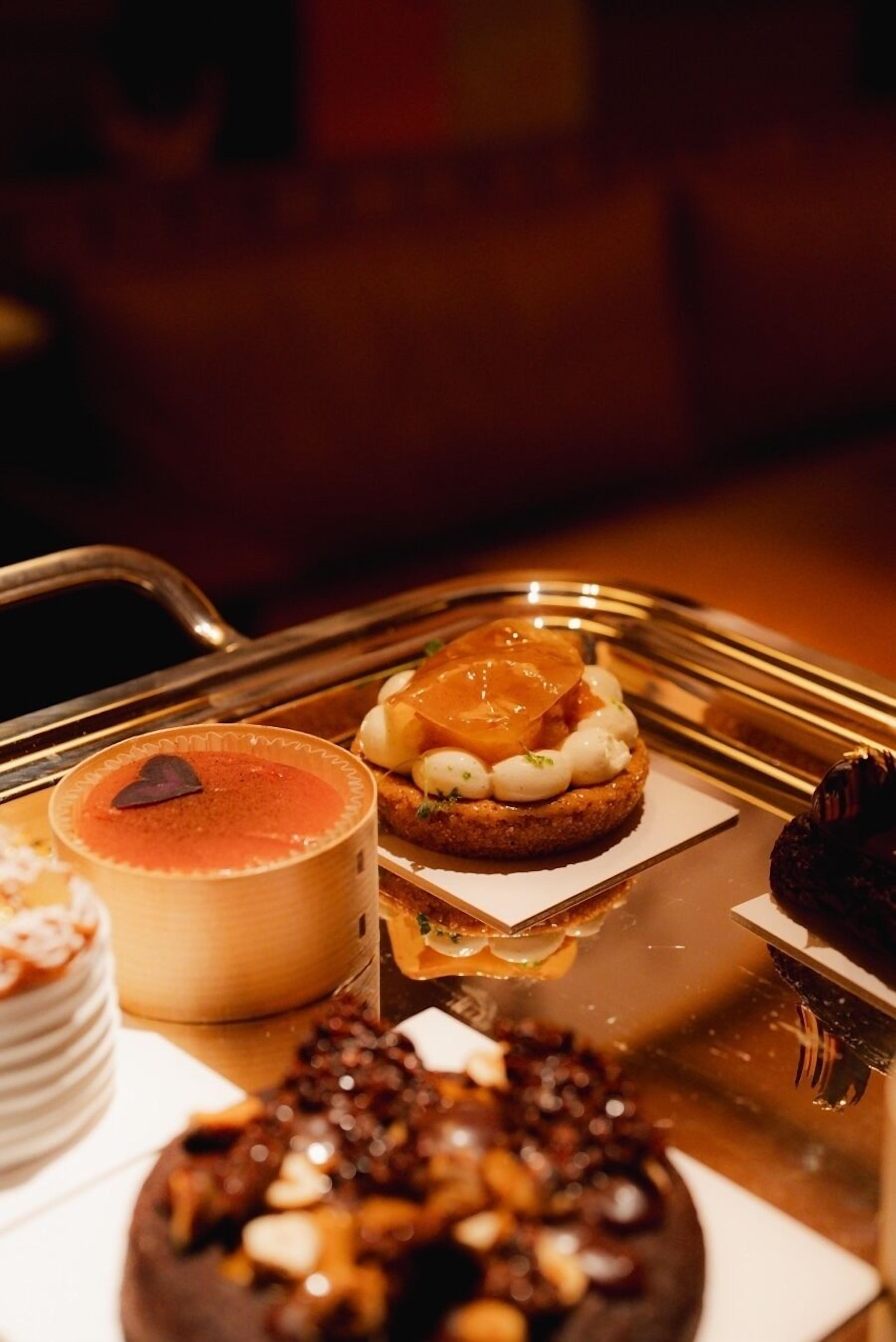 A dessert tray with various pastries and a cup of coffee.