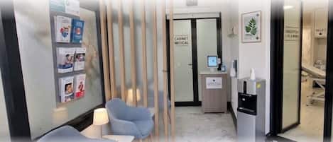 Instalación médica con recepción, botiquín y dispensador de agua.