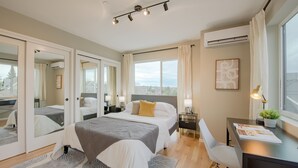 A modern bedroom with a large bed, bedside tables, a desk, and a view of the outdoors. - Seattle Charm|Near University|3 BR|W&D|WIFI (Seattle)