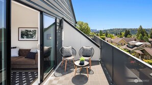 A balcony with a sofa, two chairs, and a small table. - Seattle Charm|Near University|3 BR|W&D|WIFI (Seattle)