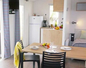 Enjoy cooking and dining in this well-equipped kitchen with a central island, refrigerator, coffee machine, and sink.