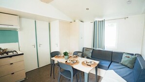 A compact kitchen with a dining table, chairs, and a sofa.