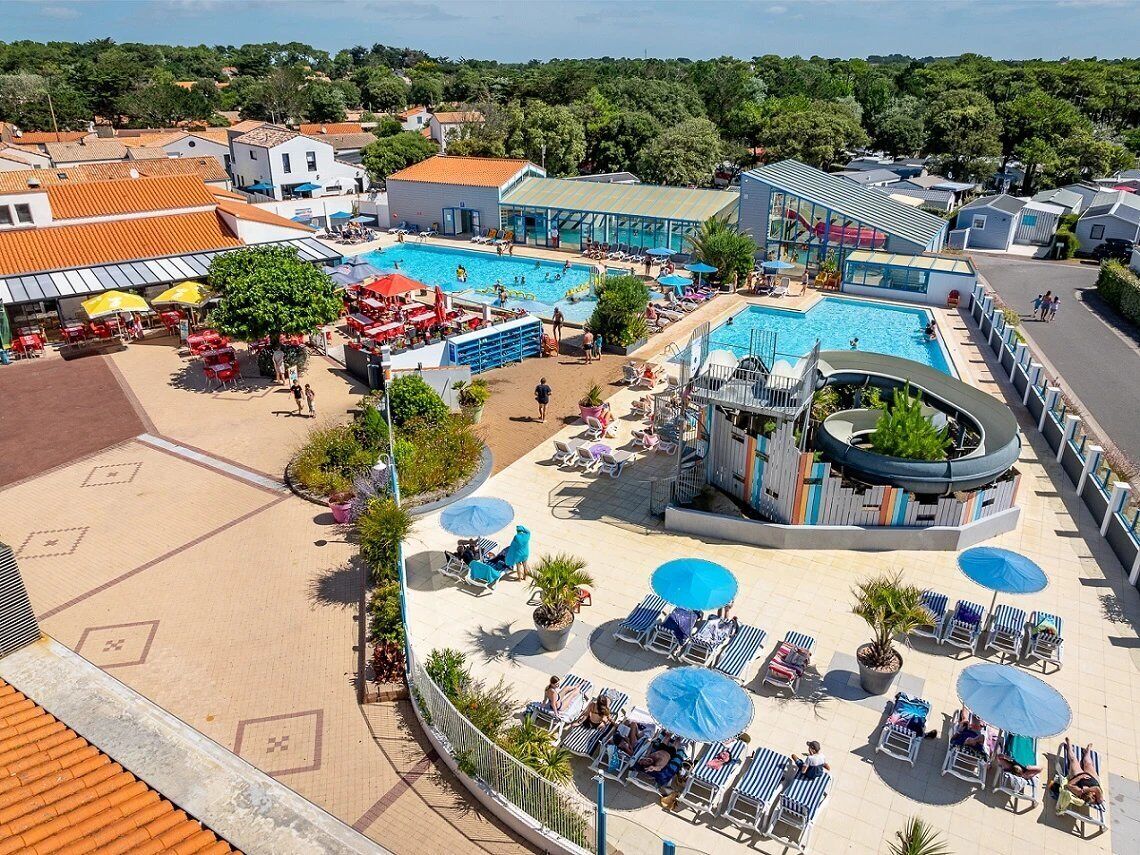 Un complexe hôtelier doté de plusieurs piscines, de chaises longues et d’espaces ombragés.