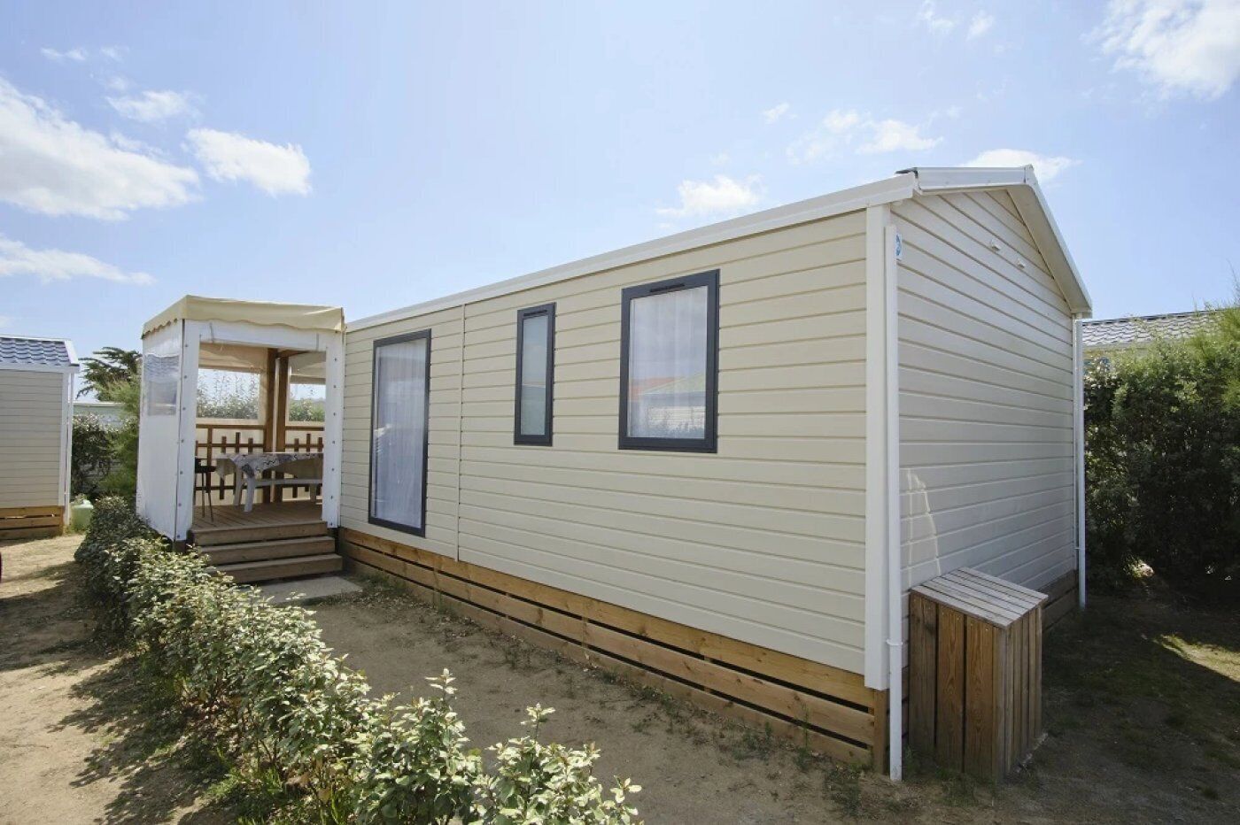 A single-story mobile home with a covered porch and a small deck.